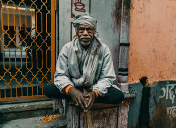 Portrait of man sitting on wall