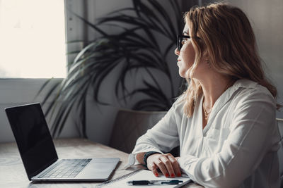 Young woman using laptop at table