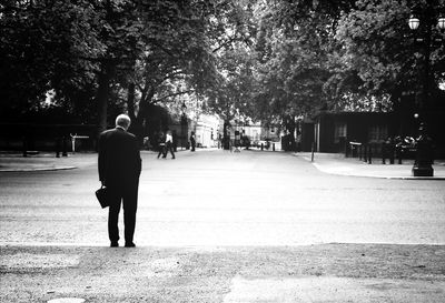 Rear view of woman walking on footpath