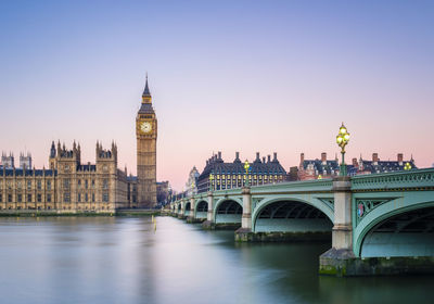 Arch bridge over river and buildings in city