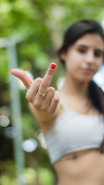 Close-up of woman showing middle finger