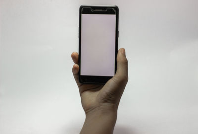 Midsection of man using mobile phone against white background