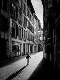 Rear view of man walking on street in city