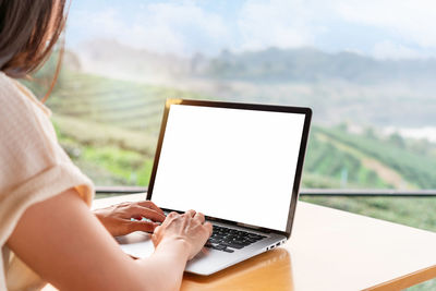 Midsection of woman using digital tablet