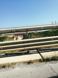 Surface level of railroad tracks against clear blue sky