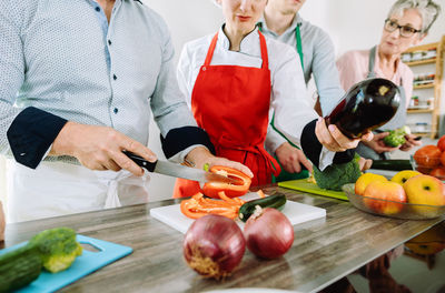 People holding food on cutting board