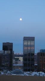 Buildings in city against clear sky during winter