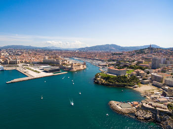 High angle view of townscape by sea against sky