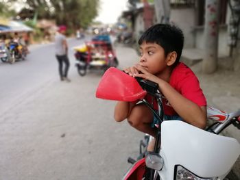 Boy riding bicycle on street in city