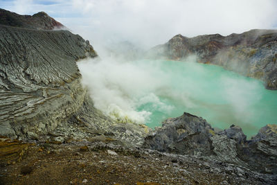 The view of green acid lake from top of mount ijen.