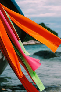 Close-up of multi colored umbrellas on beach against sky