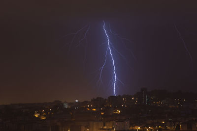 Low angle view of illuminated city against sky at night