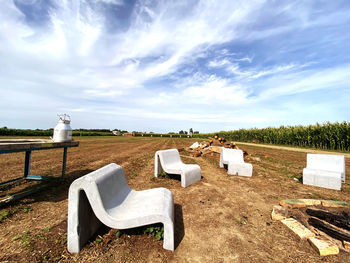 White chairs on field against sky