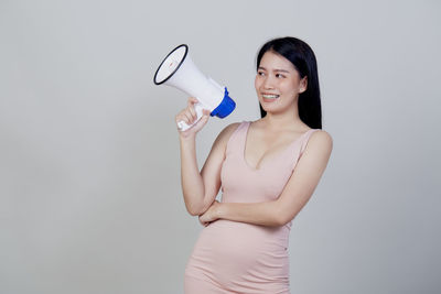 Young woman smiling against white background