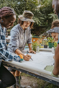 Male and female environmentalists drawing on paper in urban farm