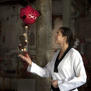 Female taekwondo artist playing with red helmet