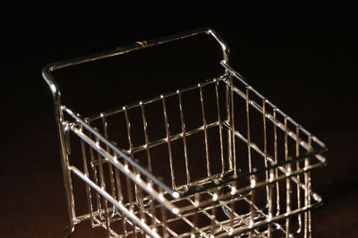 Low angle view of illuminated lighting equipment against black background