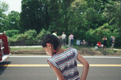 Rear view of woman standing on road