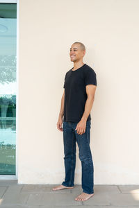 Portrait of young man standing against wall