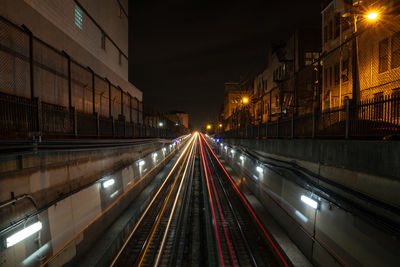 White and red light trails from a train coming out from an underground tunnel at night in chicago.