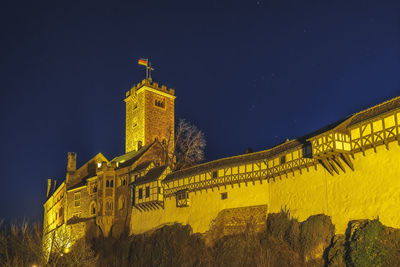 Low angle view of illuminated building against sky at night