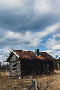 Abandoned house on field against sky