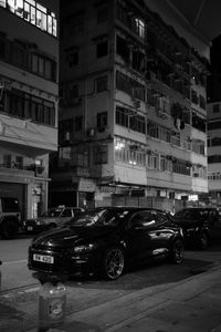 Cars parked on road against buildings in city at night