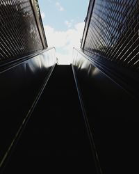 Low angle view of escalator amidst buildings in city