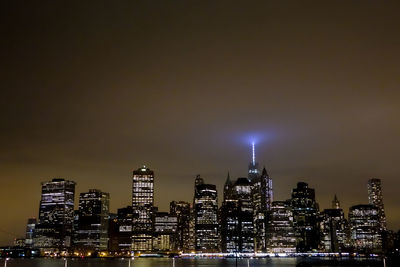 Illuminated buildings in city against sky at night