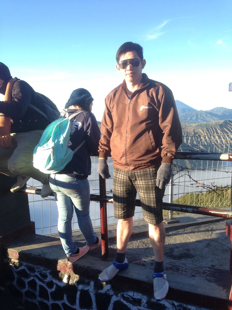lifestyles, casual clothing, leisure activity, full length, standing, young men, young adult, sunlight, sky, person, railing, sitting, men, togetherness, clear sky, mountain, three quarter length