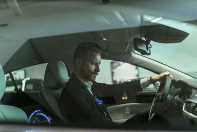 Businessman testing car in car dealership