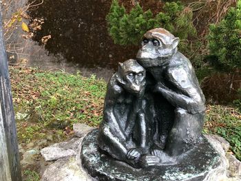 Statue on rock against trees