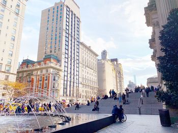 People at town square against buildings