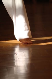 Low section of woman standing on hardwood floor