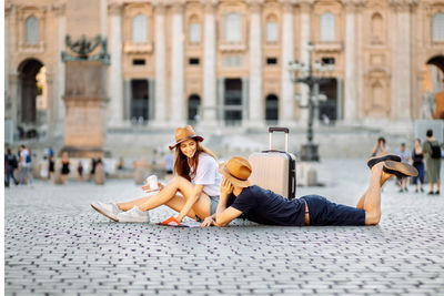 Happy tourists looking at a map and drinking coffee take away. couple of tourists on vacation