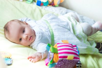 Portrait of cute baby lying on bed