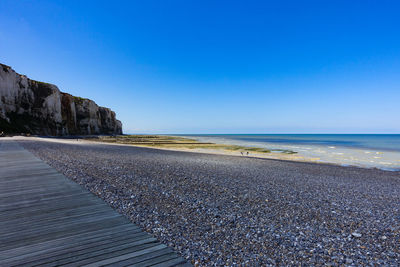 Scenic view of beach against clear blue sky