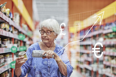 Financial chart and senior woman shopping in supermarket
