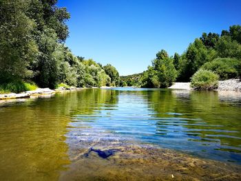 Scenic view of lake against clear blue sky