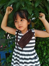 Portrait of cute girl standing by leaves