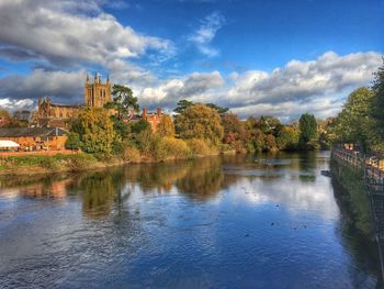 Scenic view of river by trees against sky
