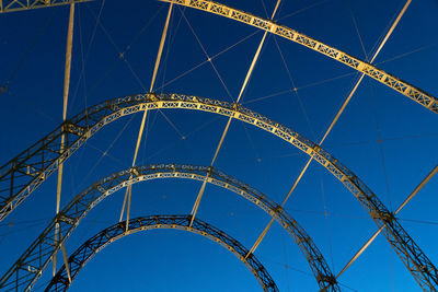 Low angle view of ferris wheel against blue sky