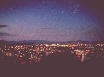 Illuminated cityscape against sky at night