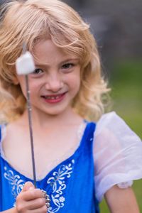 Close-up portrait of smiling girl holding marshmallow