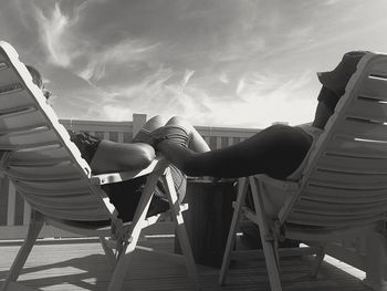 Man sitting on chair against sky