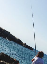 Man standing on cliff by sea