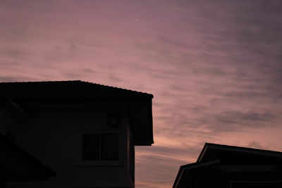 Low angle view of silhouette house against sky during sunset