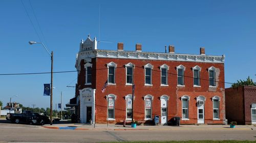 Street by building against clear blue sky