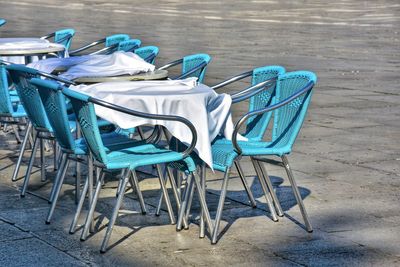 Empty chairs and tables on footpath