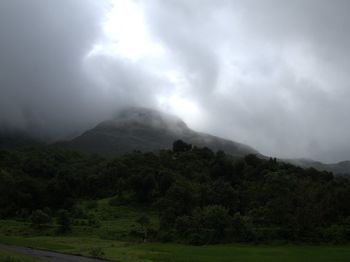 Scenic view of mountains against cloudy sky